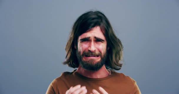 Sad, grief and young man crying in a studio with upset, worry and depression face expression. Emotions, bad news and male person from Australia with tears for broken heart isolated by gray background. - Footage, Video