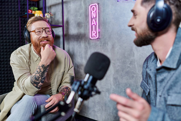 бородатий красивий інтерв'юер і його гість з навушниками в студії обговорюють питання, подкаст - Фото, зображення