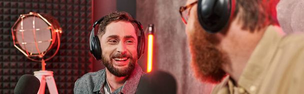 bearded handsome men in stylish attires with headphones talking actively during podcast, banner - Valokuva, kuva
