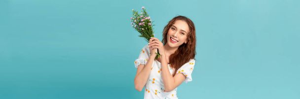 Mooi vrolijk jong meisje dragen zomer jurk, met boeket van wilde bloemen - Foto, afbeelding