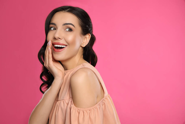 Portrait of surprised woman on pink background, space for text - Fotografie, Obrázek