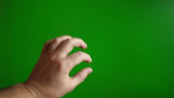 Una mano masculina en una pantalla verde hace un gesto para agrandar la imagen. Concepto de pantalla táctil. Movimiento lento. - Metraje, vídeo