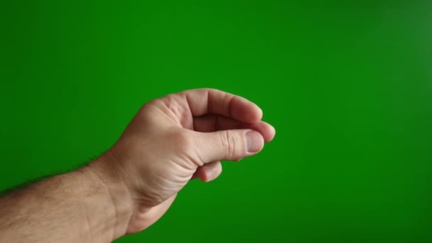 Facendo clic sulle dita di una mano maschile su uno sfondo verde. Il concetto di facilità e semplicità. Rallentatore. - Filmati, video