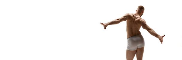 バナー。 テキストを挿入する負のスペースを持つ白い背景に対して背中の筋肉を示す裸の運動選手. メンズヘルス,美容,ボディ,スキンケア,フィットネスのコンセプト。 ボディアート - 写真・画像