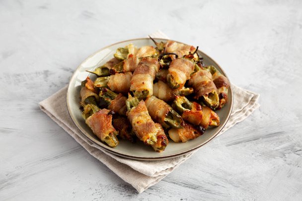 Домашние Bacon-Wrapped Jalapeno Poppers на тарелке, вид сбоку. - Фото, изображение