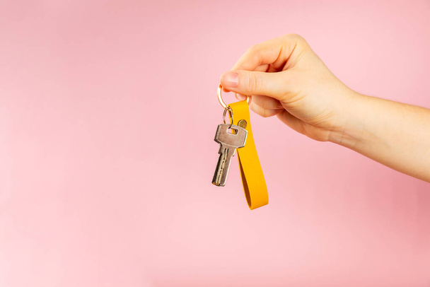 Nahka avaimenperä avaimenperä vaaleanpunainen tausta. Käsitteet kiinteistöjen ja muuttaa kotiin tai vuokrata omaisuutta. Ostan kiinteistön. Malli avaimenperä. Kopioi tilaa. - Valokuva, kuva