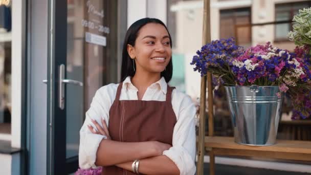 Cheerful african waitress in apron welcoming guests at door of cafe - Metraje, vídeo