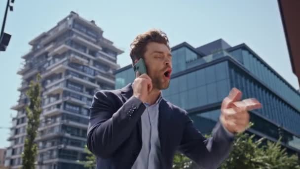 Furious manager arguing smartphone walking modern business area close up. Irritated business man yelling in cellphone going to work. Angry nervous boss quarrelling loudly expressing disappointment. - Footage, Video