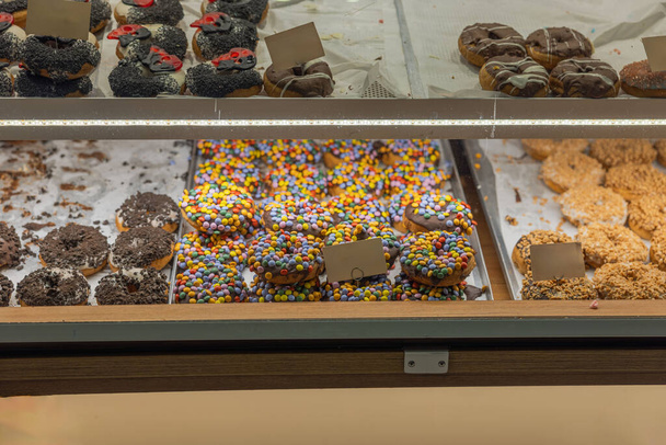 Lähikuva näkymä kahvilan hyllyt näyttää erilaisia värikkäitä donitseja. Ruotsi. - Valokuva, kuva
