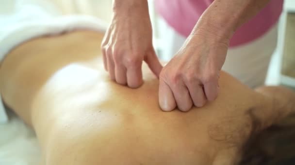 Soft focus of crop anonymous female massage therapist rubbing back of woman with hands clapped during rehabilitation - Záběry, video