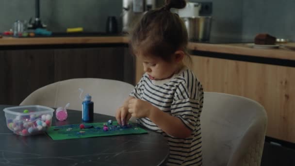A kislány színes modellagyaggal játszik, döntetlent csinál. A gyerek színes agyaggal játszik. Házi készítésű plasztilin. Lány penész modellező agyag. - Felvétel, videó