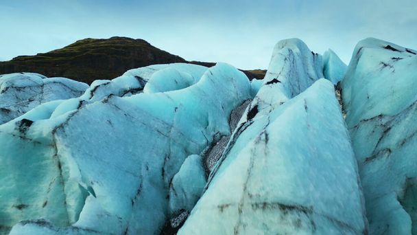 Вид з повітря на крижані скелі, що плавають на замерзлому озері, створюючи величний полярний пейзаж. Красиві ісландські пейзажі з масивною льодовиковою лагуною і тріщинами айсбергів. Повільний рух
. - Фото, зображення