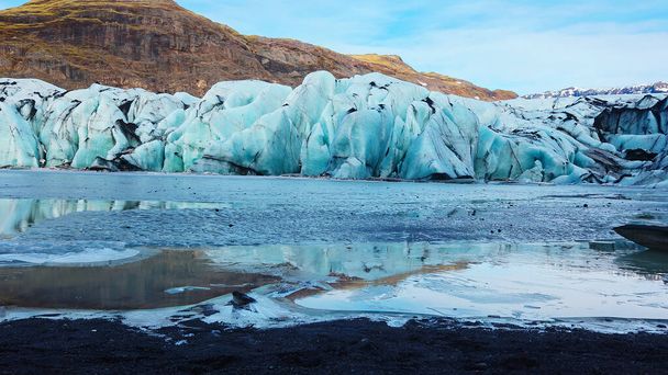 Large vatnajokull nordic ice cap next to frozen lake in icelandic landscape, majestic diamond shaped glacier in freezing cold winter scenery. Natural arctic icebergs and ice blocks. Handheld shot. - Photo, Image