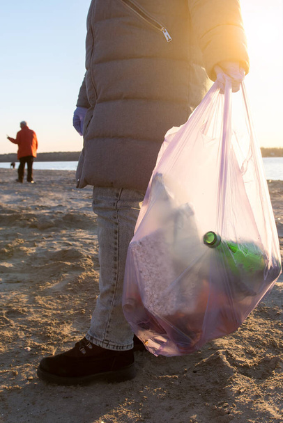 dobrovolníci uklízejí odpadky na pláži. environmentální problémy plastu v oceánu. svislá fotografie - Fotografie, Obrázek