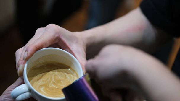 Barista εκπαίδευση πώς να κάνει ένα καφέ τέχνης latte. - Φωτογραφία, εικόνα