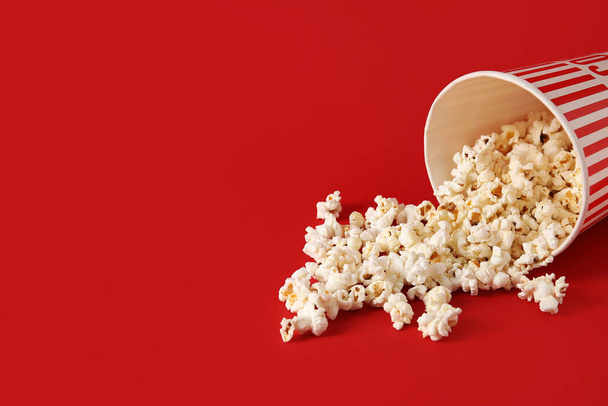 Bucket with tasty popcorn on red background - Photo, Image