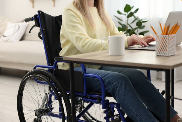 Woman in wheelchair using laptop at home, closeup - Foto, immagini