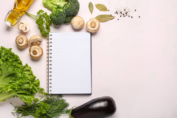 Skład z pustą książką kucharską, świeże warzywa i zioła na jasnym tle - Zdjęcie, obraz