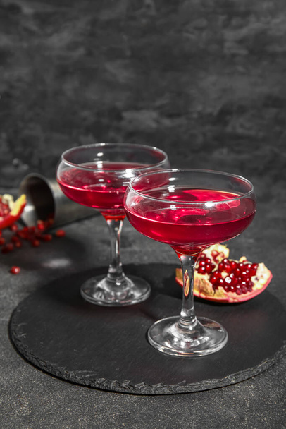 Hallituksen lasit Cosmopolitan cocktail ja granaattiomena mustalla pohjalla - Valokuva, kuva