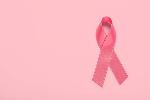 色の背景にピンクのリボン。乳がんの認知概念 - 写真・画像