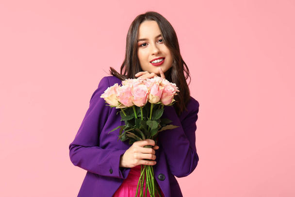 Gyönyörű fiatal nő, rózsaszín hátterű csokor rózsával. Valentin-napi ünneplés - Fotó, kép