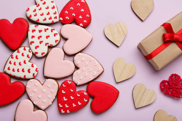 Печенье в форме сердца и подарочная коробка на сиреневом фоне. Празднование Дня Святого Валентина - Фото, изображение