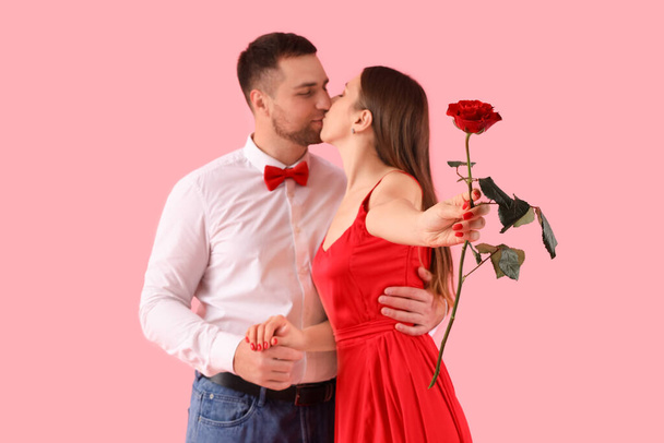 Krásný pár s růží květiny na růžovém pozadí. Valentýnská oslava - Fotografie, Obrázek