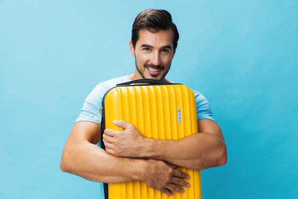 Hétvégi férfi sárga hipster jegy repülés srác nyaralás bőrönd utazás utazó utazás életmód poggyász háttér tér poggyász ünnep boldog stúdió stílus másolás kék utazás - Fotó, kép