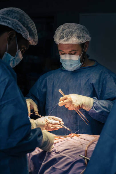 Ameliyat sırasında ameliyathanede erkek cerrahlar. Hastane ameliyatı. - Fotoğraf, Görsel