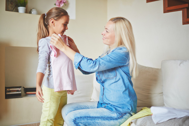 Mother fitting clothes on daughter - Photo, Image