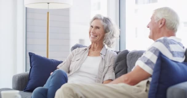 Elderly, couple and laugh conversation on sofa for love relax, connection or retirement together. Man, woman or smile talking in home for aging communication, discussion or enjoy relationship support. - Πλάνα, βίντεο