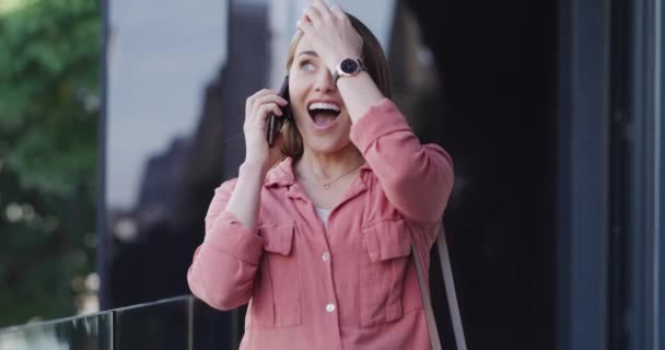 Sorriso, telefonema e mulher jovem na cidade caminhando para a comunicação com a tecnologia. Feliz, rede e pessoa do sexo feminino do Canadá em conversa móvel ou discussão com celular na cidade - Filmagem, Vídeo