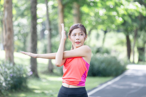 Deporte mujer calentando al aire libre, Fitness mujer haciendo ejercicio estiramiento estiramiento de su brazo - Foto, Imagen