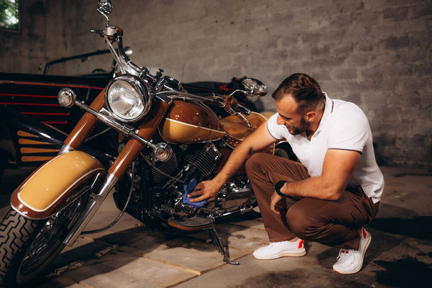 Um homem coleta motocicletas retro e carros retro em sua garagem - Foto, Imagem