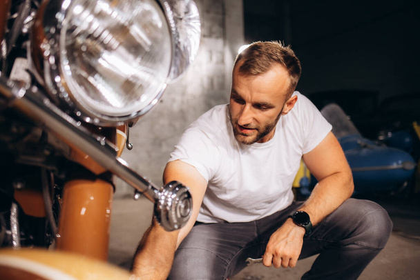 Mies pesee retro-moottoripyöränsä - Valokuva, kuva