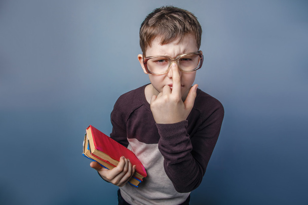 Europäisch aussehender zehnjähriger Junge in Brille, der ein Buch in der Hand hält - Foto, Bild