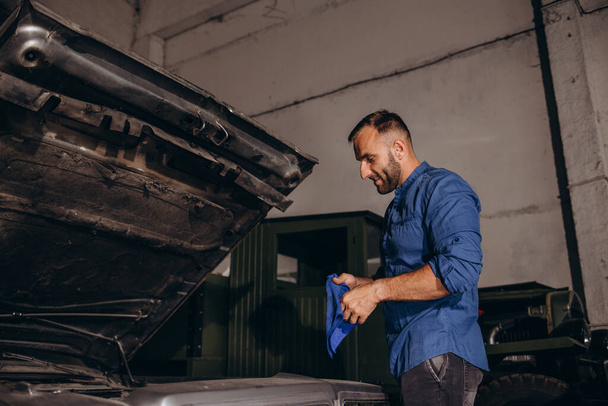 Чоловік ремонтує двигун у ретро-автомобілі - Фото, зображення