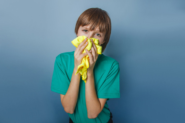 Europese uitziende jongen van tien jaar is ziek, een zakdoek, een runn - Foto, afbeelding