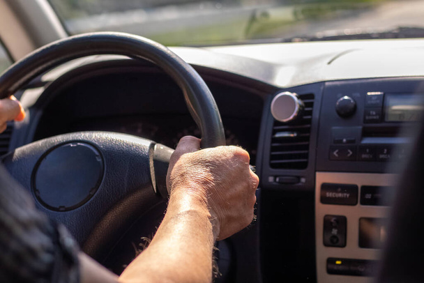 Τα χέρια των ανδρών στο τιμόνι ενώ οδηγείτε ένα αυτοκίνητο - Φωτογραφία, εικόνα