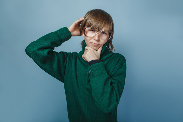 Europäisch aussehender Junge von zehn Jahren mit Brille, der auf einem grauen Kopf denkt - Foto, Bild