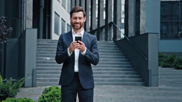Kafkasyalı başarılı iş adamı girişimci yönetici yönetici erkek CEO cep telefonu kullanıyor e-posta tarama iş haberlerini sosyal ağda şehir merkezindeki akıllı telefondan kontrol ediyor - Video, Çekim