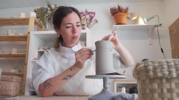 Donna artigiana in grembiule che fa un vaso di ceramica nel suo laboratorio. Hobby e artigianato concetto. - Filmati, video