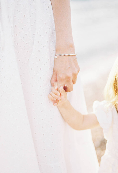 Little flower girl holds bride finger. Cropped. Faceless. High quality photo - Photo, Image