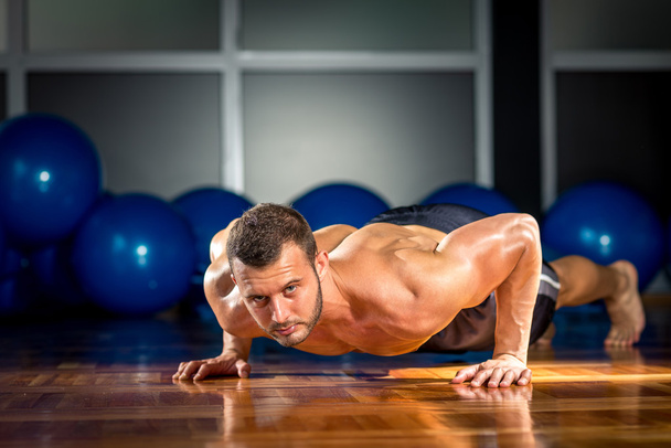 Man doing push-ups in gym - Photo, image