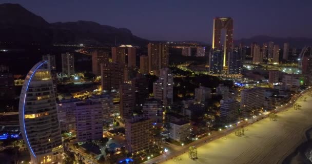 Вид с воздуха на прибрежные здания ночью в Бенидорме, Испания. Воздушный вид на Бенидорм. Мирные пляжи и гладкое Средиземное море с уличными фонарями, зависающими вдали. - Кадры, видео