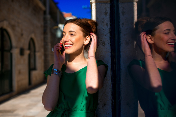Vrouw met mobiele telefoon in de oude stad straat - Foto, afbeelding