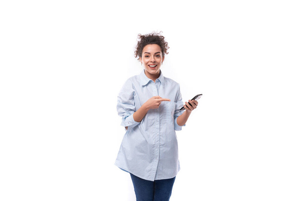 okouzlující mladá brunetka kudrnaté obchodní žena v modré košili na bílém pozadí s kopírovat prostor. - Fotografie, Obrázek