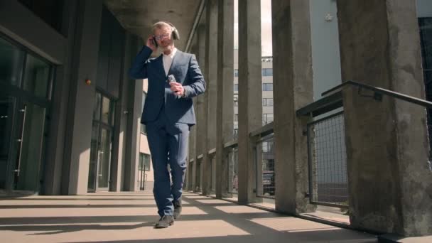 Gris pelo jubilado maduro senior hombre de negocios funky divertido feliz despreocupado empresario libre bailando caminando en la ciudad en las escaleras de la oficina celebrar el viernes la libertad de escuchar música en los auriculares - Metraje, vídeo