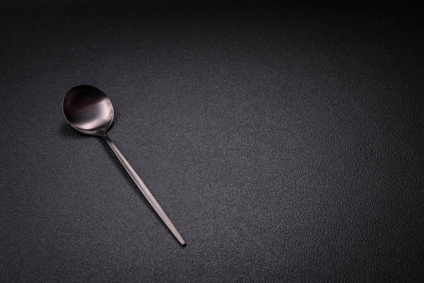 Empty metal spoon on dark textured concrete background. Cutlery, preparation for dinner - Photo, Image
