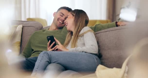 Happy, couple and reading phone with social media, meme or funny post, internet video or website for online shopping. Man, woman and talking about streaming, mobile app or relax in home on sofa. - Footage, Video